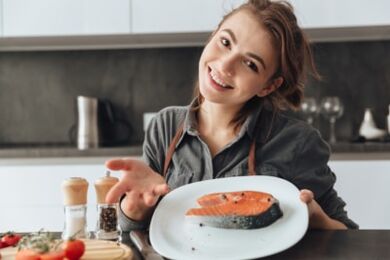 Младо момиче с пържола от пъстърва